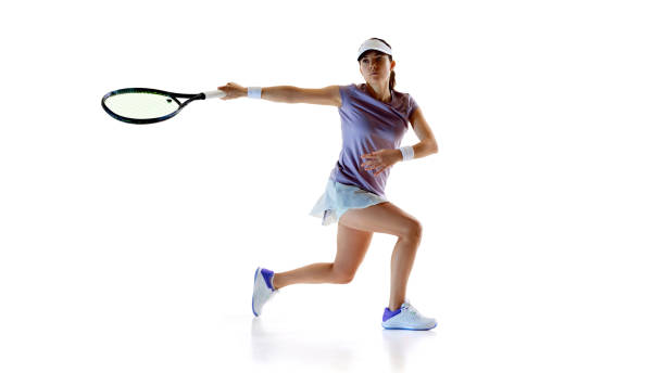 istock Stepping forward with intent, tennis athlete extends her racket, ready for forehand shot against white studio background. 2186750482