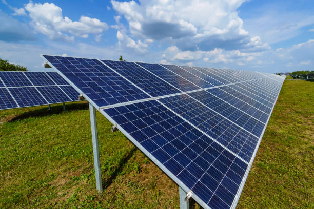 istock Solar panels installed in a green field under a partly cloudy sky. Solar panels capture sunlight in a sunny field surrounded by nature, promoting renewable energy solutions. 2186750502