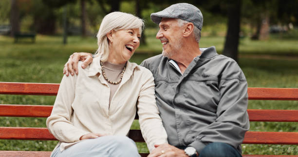 istock Senior couple, hug and laughing in park for bonding, conversation and commitment together outdoors. Retirement, marriage and mature man and women in nature on bench for love, care and connection 2186751227