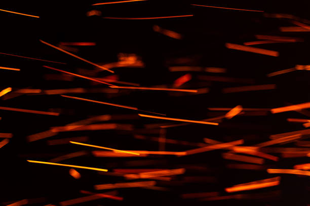 Bright sparks flying from a campfire during a cozy evening outdoors. The warmth of a campfire creates bright sparks dancing in the night sky