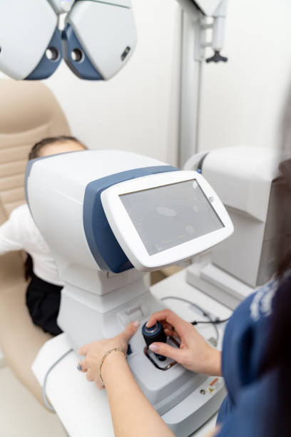 istock Advanced eye exam at clinic. A patient is seated for an eye examination using sophisticated diagnostic equipment in a modern clinic setting. 2186751906