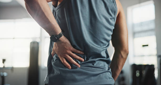 man, hands and back pain with injury at gym for muscle tension, workout accident or sprain. closeup, male person or athlete with sore spine, pinch nerve or ache for joint inflammation at health club - dor de costas imagens e fotografias de stock