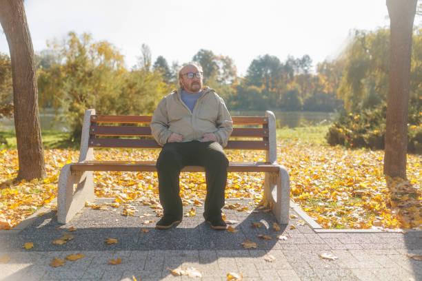 istock Senior man enjoying the autumn scenery while sitting on a park bench 2186755487