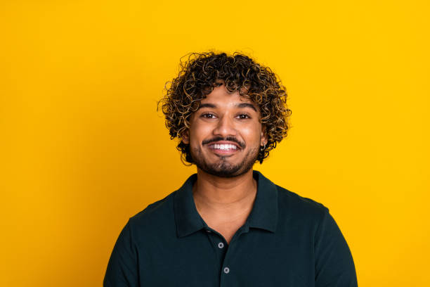 istock Confident young man smiling against a vibrant yellow background expressing joy and positivity 2186755897
