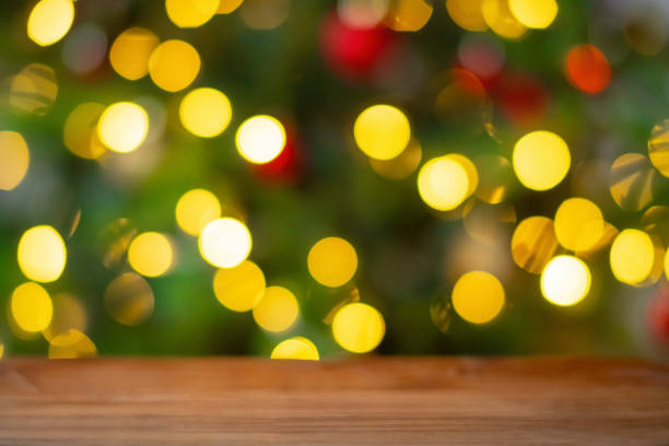 istock Christmas tree lights and wooden table background 2186764170