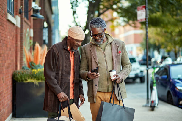 istock Weekend shoppers pausing with bags to check smart phone 2186766308
