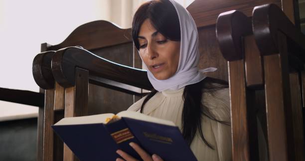 istock Woman explores scripture in quiet Catholic church setting. Scene reflects reverence for tradition, sacred connection, and deep spiritual journey. Concept Religion and Prayer Catholicism and traditions 2186768187