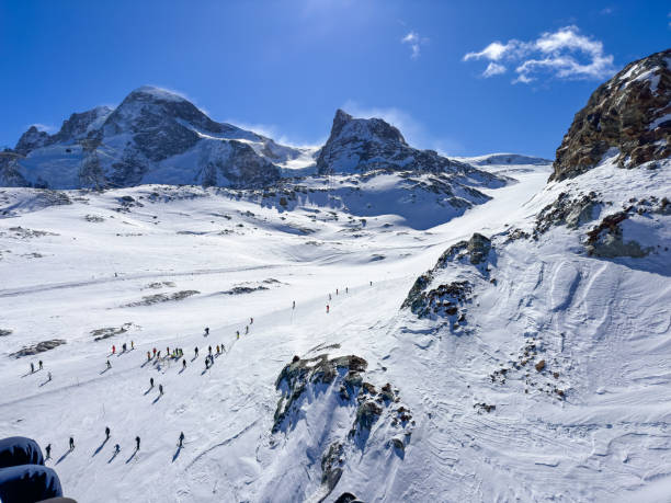 Country border dividing ski slopes of winter ski resorts Zermatt, Switzerland and Cervinia, Italy. View from Italy side.