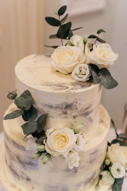 istock Elegant Three-Tier Wedding Cake with White Roses and Eucalyptus 2186769135