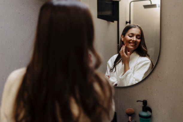 istock Young woman putting on makeup 2186771826
