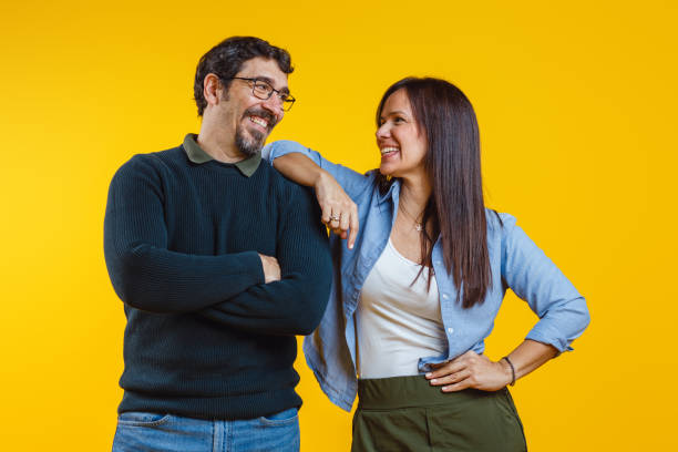 istock Cheerful Couple Sharing a Laugh on Yellow Background 2186771993