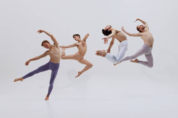 istock Dancers' synchronized leaps embody essence of creating art through intense physical training and dedication against white studio background. 2186772656