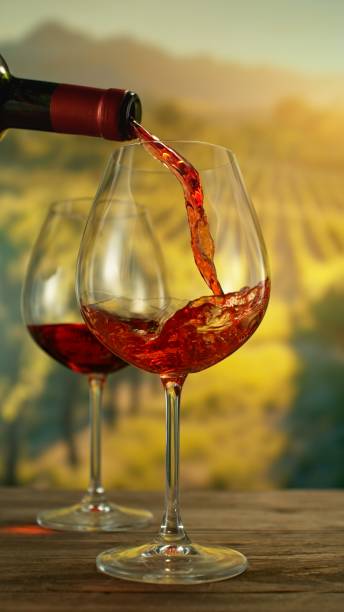 Close-up of red wine pouring into glass Close-up of red wine pouring into glass on vineyard with sunset liquor store counter photos stock pictures, royalty-free photos & images