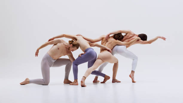 istock Male ballet dancers captured in synchronized motion, showcasing their athleticism and grace in perfect dance against white studio background. 2186772749