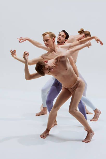 istock Three dancers strike dramatic pose, their movements embodying strength and expressive storytelling against white studio background. 2186772812
