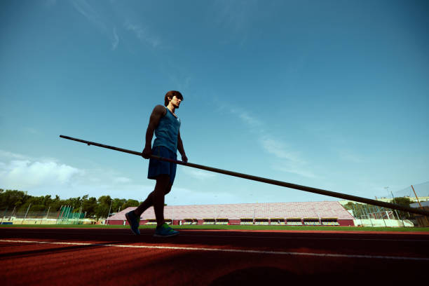 istock Young man practicing pole vaulting with determination at outdoor stadium track, athlete preparing for intense training session 2186776058