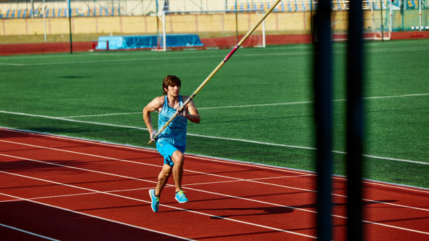 istock Motivated pole vaulter, muscularly young man in blue sportswear in motion with pole, practicing with precision and strength on track. 2186776062