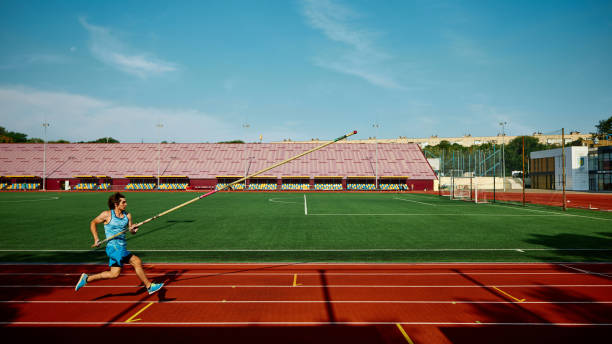 istock Motivated young athlete practicing for pole vaulting championship, competitive and focused man in motion, running with pole at stadium 2186776065
