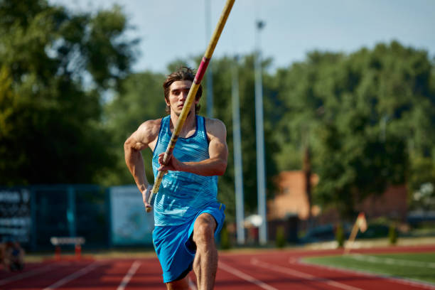 istock Pole vaulting athlete training on outdoor stadium track, aiming for new heights, focused man running with pole, showing skills 2186776070
