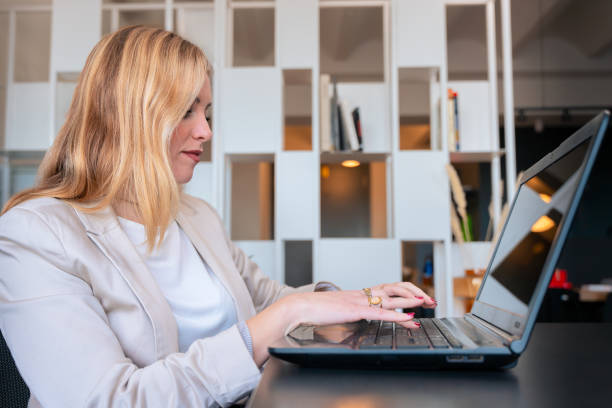 istock Woman working on laptop in modern office environment 2186776430