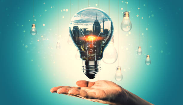 istock Creative lightbulb with cityscape inside over a hand on turquoise background. 2186776850