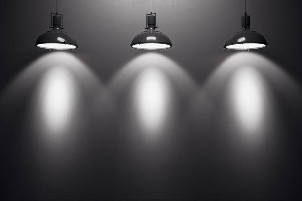 istock Three black lamps illuminating a blank dark wall in an empty room. 3D Rendering 2186777015