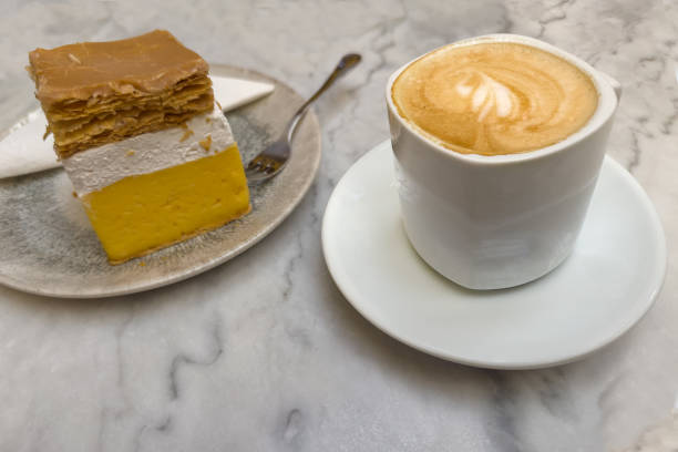 Cappuccino with drawing on foam in cup served with cake