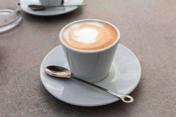 istock Cappuccino with drawing on foam in cup on gray table 2186778940