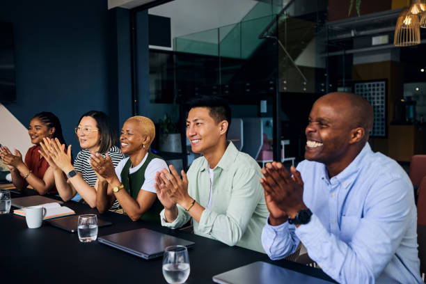 istock Happy multi-ethnic colleagues clapping hands during a productive meeting in a contemporary office space 2186780883