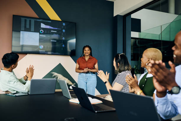 Diverse business team clapping for a successful presentation in modern office
