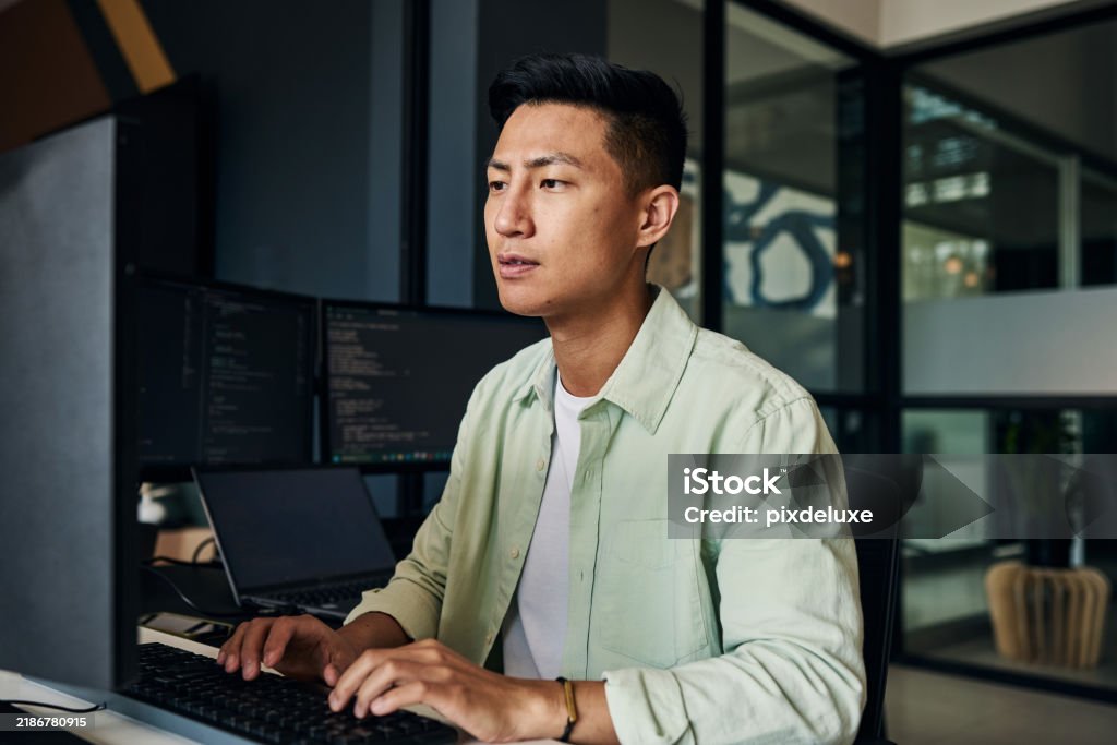 Young Asian Man Working As Software Developer Coding On Computer In ...