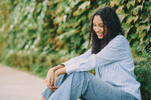 istock A Smiling Young Woman Sitting Outdoors, Surrounded by Lush Greenery in a Beautiful Setting 2186781309