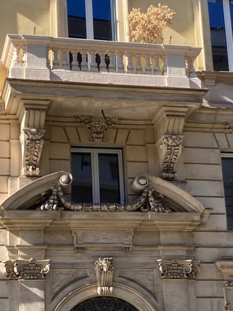 istock Rounded arch doorway with segmental pediment, two pilasters with Doric capitals, allegorical heads, garlands and acanthus leaves decorating, balustraded balcony above. 2186785419