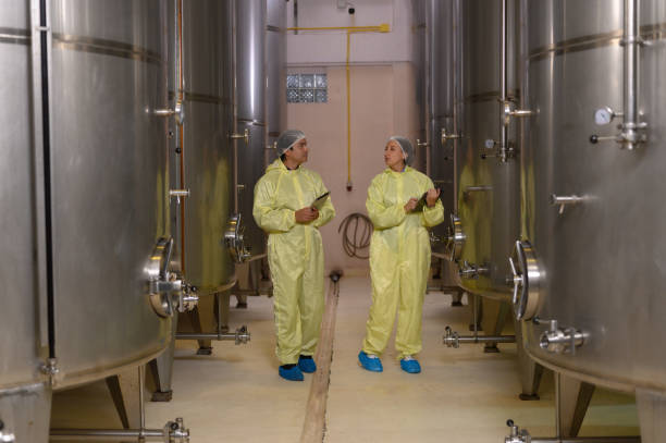 istock Wine production engineers work in the beverage industry in large modern wineries and test wines in winery warehouses. 2186797032