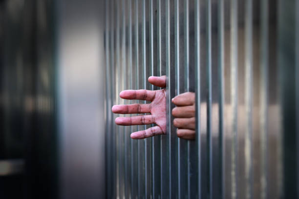 istock Hand Reaching Through Metal Bars Symbolizing Confinement and Hope 2186808856