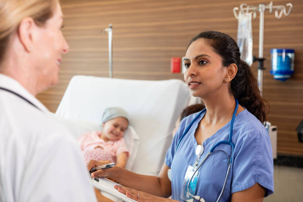 istock Pediatric nurse talks with oncologist about young patient's condition 2186814667