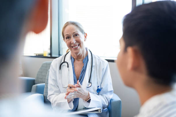 istock Mature doctor talks with twin brothers 2186814673
