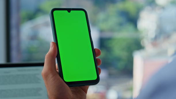 istock Man hand holding mockup smartphone at workplace closeup. Unknown businessman 2186816916