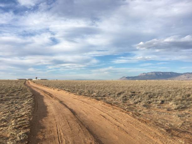 istock dirt road leading to mountains 2186817257