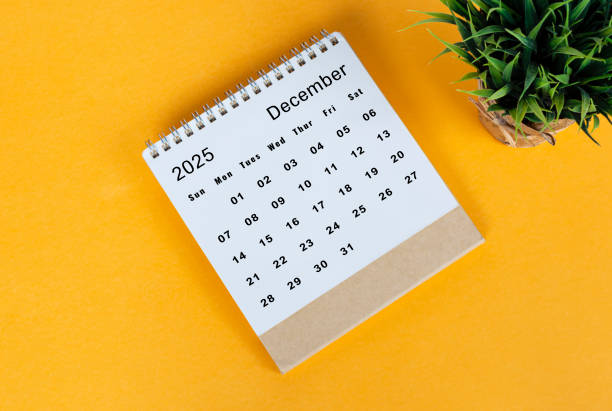 istock December 2025 desk calendar on yellow background. Directly above. Flat lay 2186818321