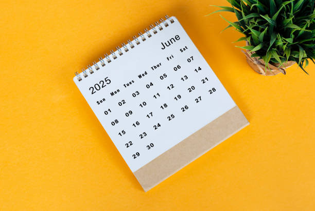 istock June 2025 desk calendar on yellow background. Directly above. Flat lay 2186818322