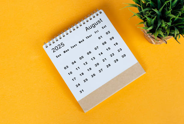August 2025 desk calendar on yellow background. Directly above. Flat lay