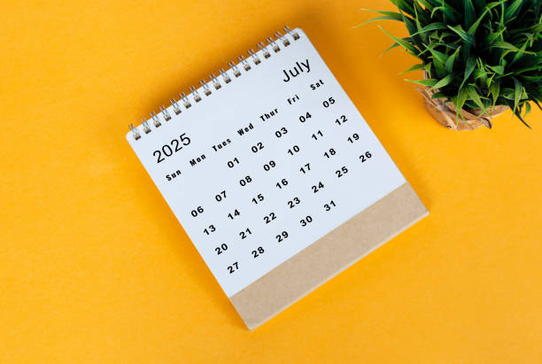 istock July 2025 desk calendar on yellow background. Directly above. Flat lay 2186818327