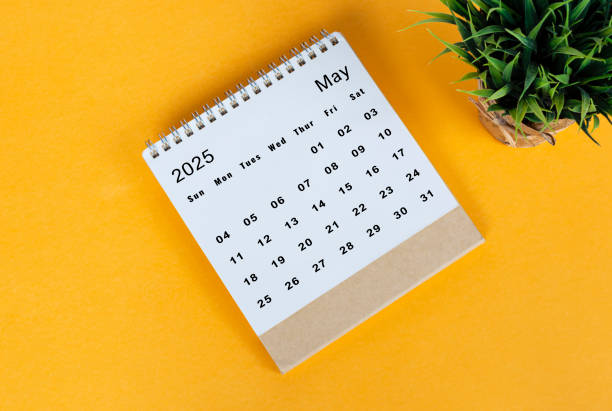 istock May 2025 desk calendar on yellow background. Directly above. Flat lay 2186818385