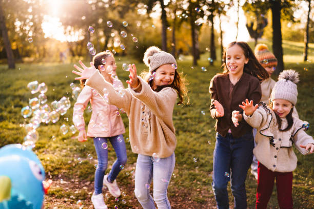 istock Children have fun catching soap bubbles in the park 2186820024