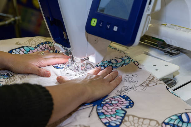 Hands of a woman sews on a modern sewing machine. Textile industry