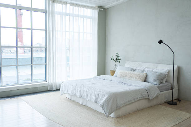 istock Stylish loft bedroom interior. Spacious design apartment with light walls large windows big bed. Clean modern decoration with elegant furniture in minimalist Scandinavian style 2186822018