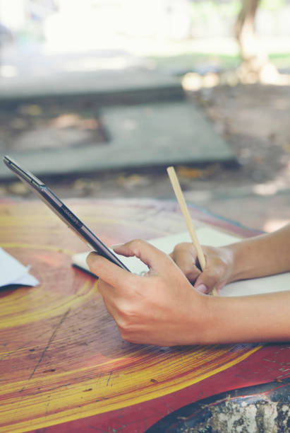 istock Planner or organizer writing daily appointment On Calendar book and using tablet. Asian woman hand plan timetable meeting agenda and note schedule business in diary. Planner concept-vertical. 2186822459