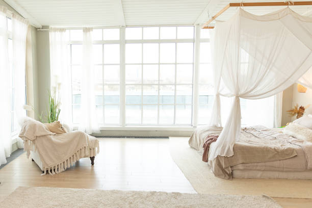 istock Stylish loft bedroom interior. Spacious design apartment with light walls large windows big bed. Clean modern decoration with elegant furniture in minimalist Scandinavian style. 2186824064