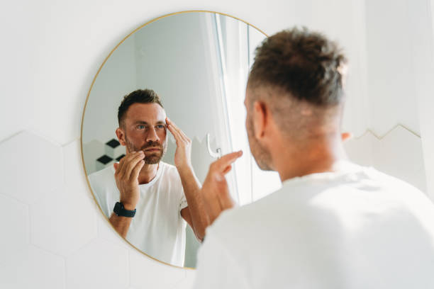 istock A millennial man is using a face cream in the bathroom 2186824810